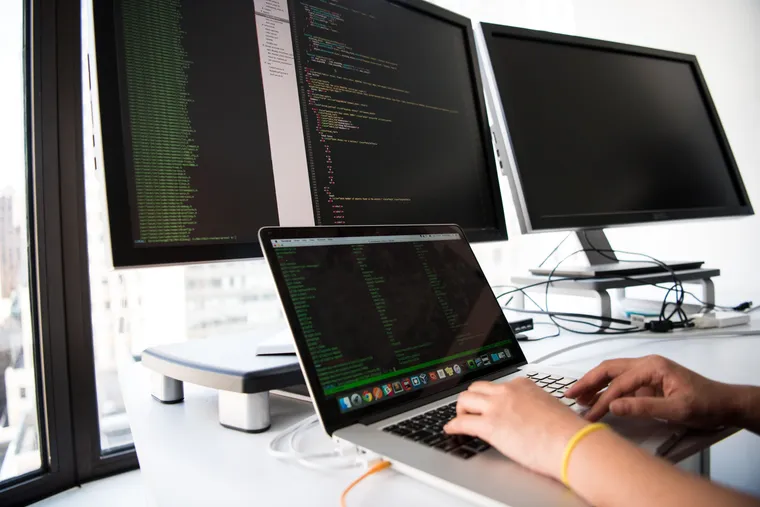 A software developer working across multiple screens of code
