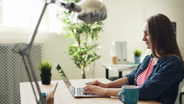 A professional working at a laptop in a tidy home office